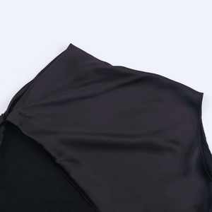 Détail du tissu satiné noir montrant la découpe asymétrique et la finition lisse des coutures