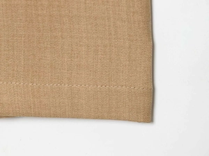 Close-up of khaki twill fabric stitching detail on high-waist wide-leg trousers