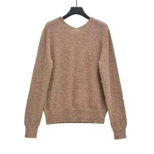 Detailed view of brown knit sweater with fuzzy texture and ribbed cuffs for women