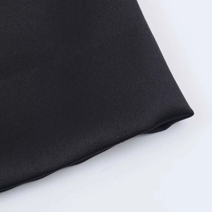 Vue macro détaillée de la texture du tissu en maille noire de la robe asymétrique élégante