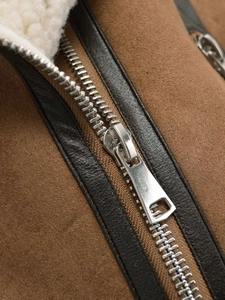 Detail of faux suede vest with contrast sheepskin lining and silver metal zipper