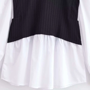 Chic black and white two-piece patchwork top featuring ribbed knit and a pleated hemline