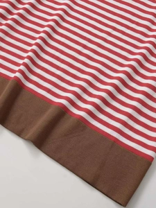 Détail du tissu en maille rayée rouge et blanc avec une bordure en côtes marron foncé