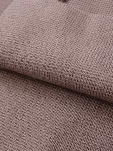 Detaillierte Nahaufnahme von braunem Waffelstrickstoff mit weicher Textur und Webmuster