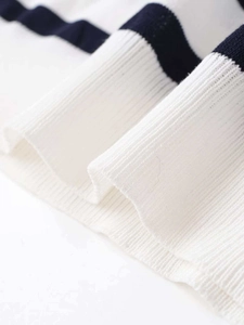 Macro detail of ribbed knit texture on a classic navy and cream striped sweater hem