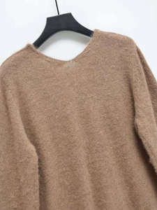 Detailed close-up of brown fuzzy V-neck knit sweater featuring soft mohair texture