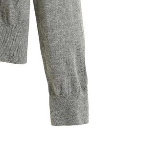 Detailed close-up of ribbed cuffs on grey knit cardigan with high-quality stitching