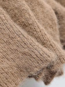 Macro close-up of khaki plush knit fabric showing soft mohair texture and warm fibers