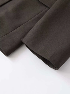 Macro shot of dark brown suit cuffs showing high-density refined fabric and fine stitching