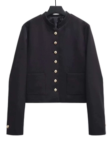 Close-up of black jacket featuring vintage gold embossed buttons and standing collar detail
