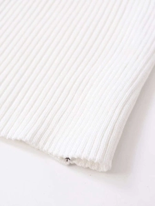 Close-up of white ribbed knit fabric texture and high-quality hem finishing detail