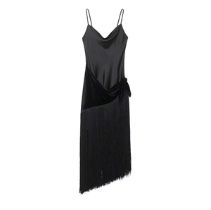 Detail of black satin slip dress featuring velvet panels and long fringe hemline