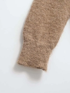 Close-up of brown long-pile mohair knit fabric showing ribbed cuffs and soft texture