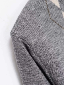 Detailed close-up of gray knit cardigan with diamond pattern and stitching quality