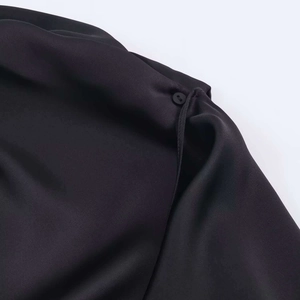 Gros plan sur le détail du bouton noir d'une élégante robe d'été noire asymétrique