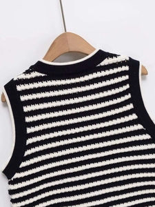 Detailed view of black and white striped knitted vest with white crew neck collar