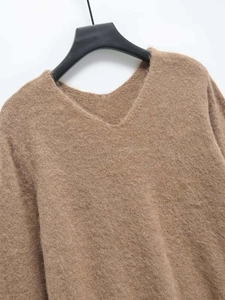 Close-up of soft brown V-neck knit sweater showing the fluffy mohair texture and stitching