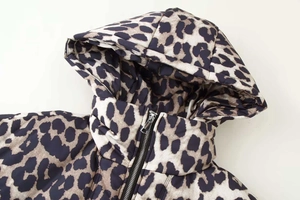Detail shot of the zip-up closure and leopard print hood on this stylish winter coat