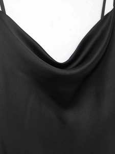 Close-up of black satin dress featuring an elegant cowl neck and thin spaghetti straps