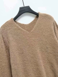 Detailed view of the fluffy brown V-neck knit sweater featuring soft mohair texture