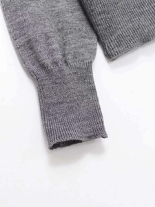 Close-up of gray knit sweater cuff showing fine ribbed texture and premium material