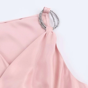 Detail des rosa Satinoberteils mit silbernen Perlenringen an den Schultergurten