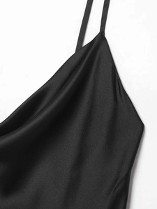 Detail of elegant black satin dress featuring thin straps and draped cowl neckline texture