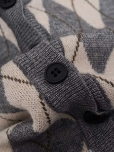 Close-up of grey and cream argyle knit cardigan with black buttons and soft texture