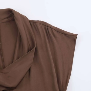 Detail view of draped neckline and silky chocolate brown fabric on a midi dress