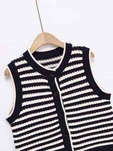 Close-up of navy and white striped knit vest with textured fabric and dark buttons