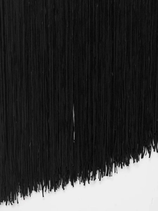 Macro shot of dense black fringe tassels on a dress with a clean white background