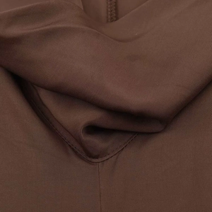 Macro detail of dark brown stretch midi dress fabric showing fine knit and stitching
