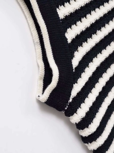 Detailed macro view of black and white striped knit vest with white ribbed edging