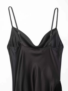 Detail of adjustable thin shoulder straps and cowl neck on a black satin dress