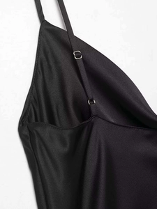 Detail of adjustable silver metal buckles on slim black satin straps with neat stitching