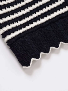 Detailed macro view of black and white striped knit fabric with wavy scallop hemline