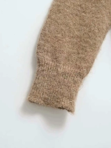 Close-up of camel fuzzy knit sweater featuring ribbed cuffs and soft plush texture