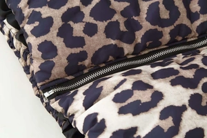 Detailed macro view of the leopard print jacket featuring a smooth metallic zipper closure