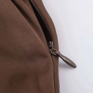 Close-up of brown midi dress featuring a seamless invisible zipper and bronze metal puller