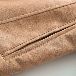 Detail of suede trench coat showing a clean welt pocket and high-quality stitching