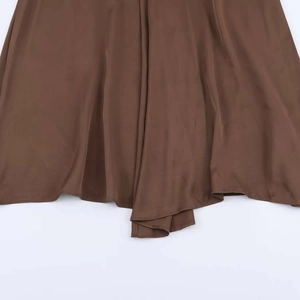 Close-up of brown satin midi dress showing double-layered hem and silky drape texture