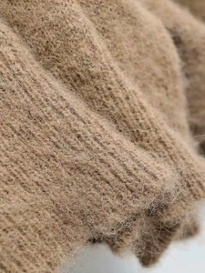 Close-up of brown mohair knit fabric showing soft fluffy fibers and coarse texture