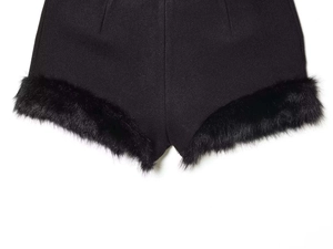 Dettaglio di pantaloncini neri a vita alta con bordo in pelliccia sintetica e tessuto