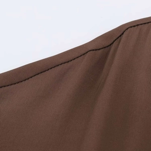Detailed macro view of the premium brown fabric texture and precise stitching on the midi dress