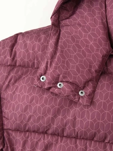 Détail de la veste matelassée violet foncé avec motifs géométriques et boutons à pression