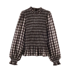 Detail of gingham blouse featuring elastic smocked chest and ruffled stand-up collar design