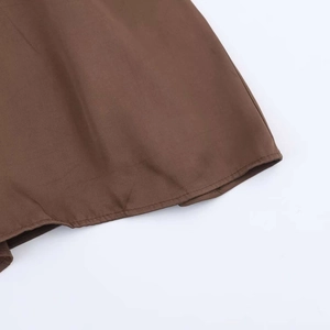 Detail of dark brown midi dress hemline showing high-quality stitching and plain weave fabric
