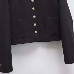 Classic black jacket with textured fabric and vintage embossed gold metal buttons