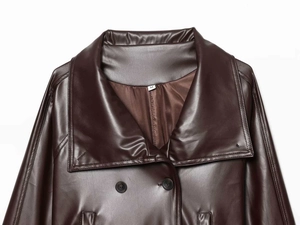 Détail macro du revers et du col d'une veste en cuir bordeaux avec étiquette taille M