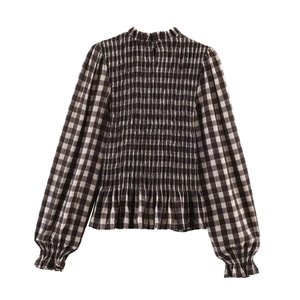 Detailed view of vintage gingham blouse featuring smocking texture and ruffled high neck